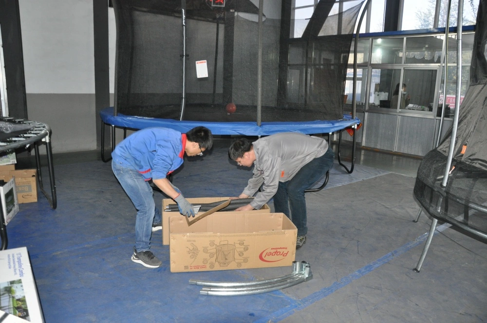Trampoline Pre-production Inspection Workers inspect trampoline accessories before assembly in factory workshop